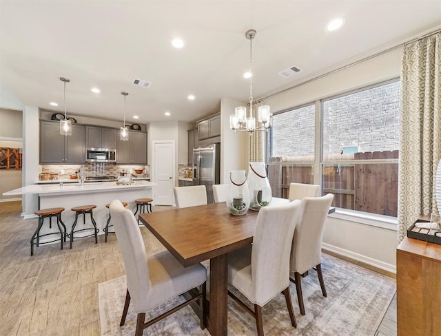 dining space featuring light wood finished floors, visible vents, recessed lighting, and baseboards