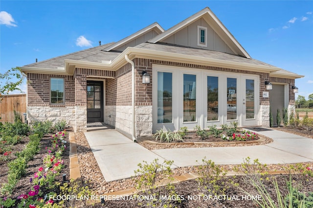 view of front of home featuring a garage, stone siding, fence, board and batten siding, and brick siding