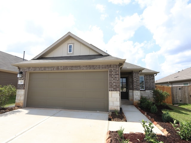597 Copper Springs Dr, Magnolia, TX 77354 - view of front of home with board and batten siding, concrete driveway, a garage, brick siding, and stone siding
