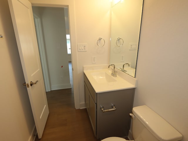 597 Copper Springs Dr, Magnolia, TX 77354 - half bathroom with wood finished floors, toilet, vanity, and baseboards