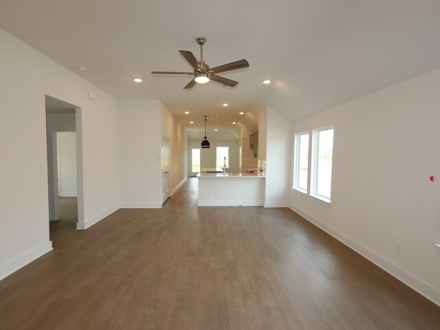 597 Copper Springs Dr, Magnolia, TX 77354 - unfurnished living room featuring ceiling fan, baseboards, dark wood-style floors, recessed lighting, and vaulted ceiling