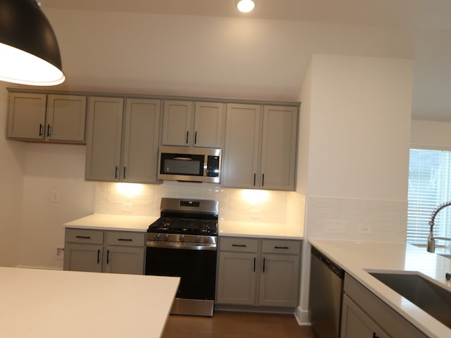 597 Copper Springs Dr, Magnolia, TX 77354 - kitchen with appliances with stainless steel finishes, gray cabinets, light countertops, decorative backsplash, and recessed lighting
