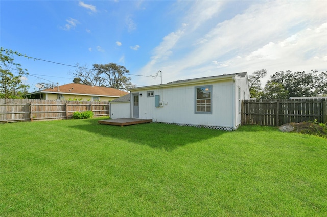 rear view of house with a yard and a deck