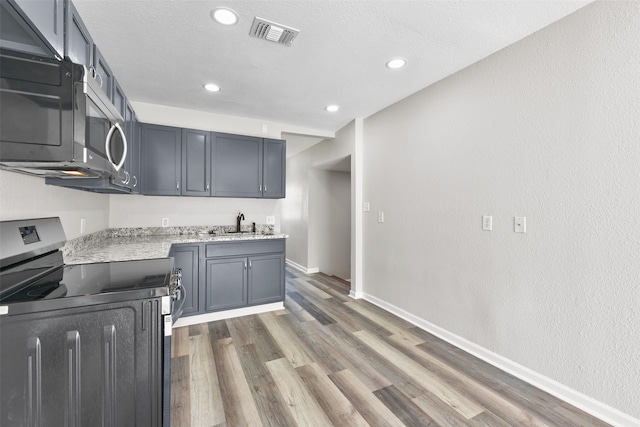 kitchen featuring sink, a textured ceiling, stainless steel electric range, dark hardwood / wood-style flooring, and gray cabinetry