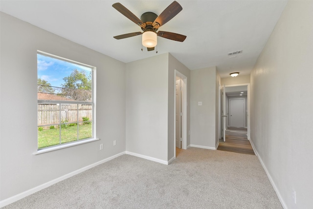 empty room with ceiling fan and light colored carpet