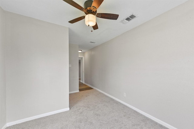 empty room featuring light colored carpet and ceiling fan