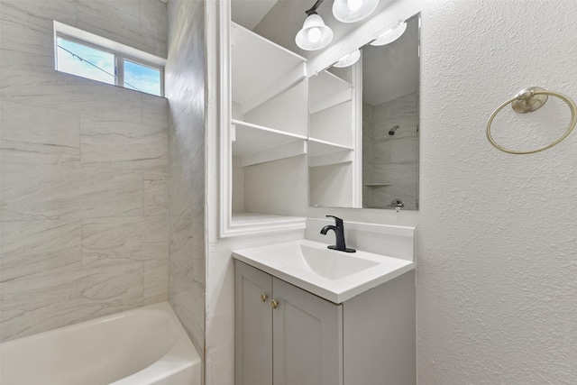 bathroom with tiled shower / bath combo and vanity