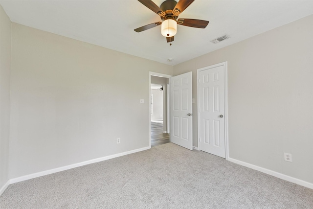 unfurnished bedroom featuring ceiling fan, light colored carpet, and a closet