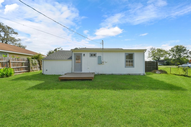 back of property with a lawn and a wooden deck