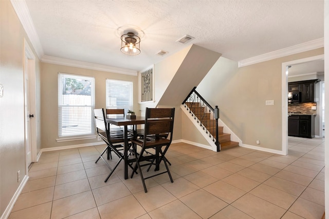 dining space featuring a textured ceiling, crown molding, and light tile patterned floors