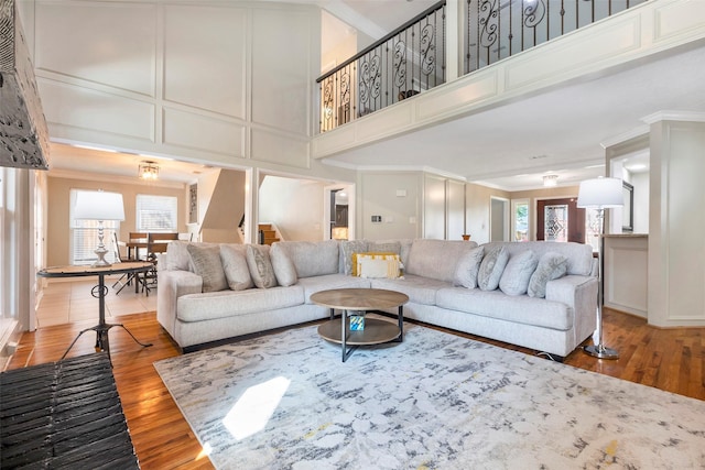 living room with a towering ceiling, hardwood / wood-style floors, and a healthy amount of sunlight