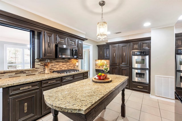 kitchen with stainless steel appliances, light stone countertops, decorative light fixtures, light tile patterned flooring, and tasteful backsplash