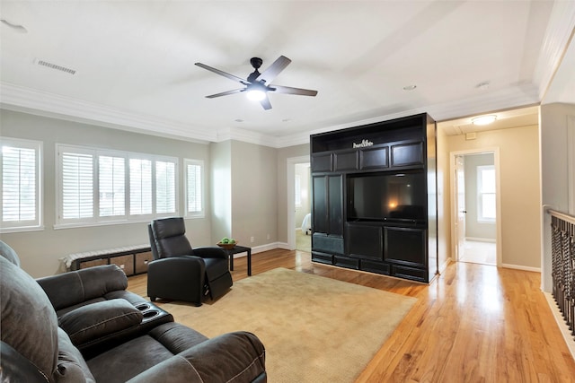 living room with ornamental molding, ceiling fan, and light wood-type flooring