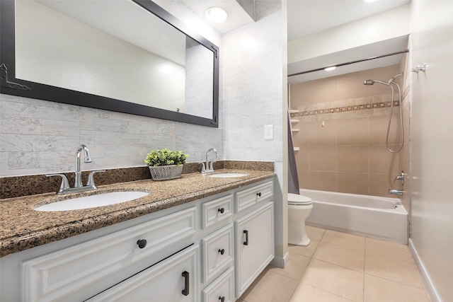 full bathroom featuring toilet, tile patterned flooring, tiled shower / bath, and vanity