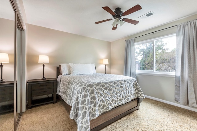 bedroom with ceiling fan, a closet, and light carpet