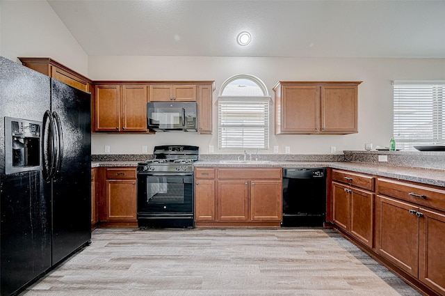 kitchen with light hardwood / wood-style floors, black appliances, and sink