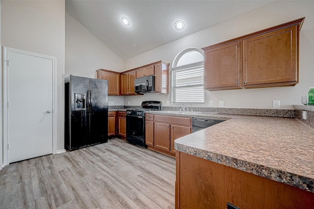 kitchen with high vaulted ceiling, light wood-type flooring, black appliances, and sink