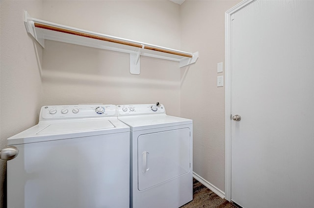 clothes washing area with washer and dryer and dark wood-type flooring