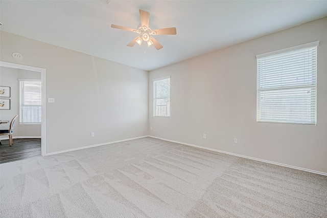 spare room with ceiling fan, light carpet, and a healthy amount of sunlight