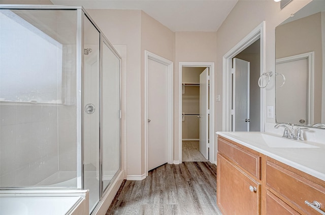 bathroom featuring a shower with door, vanity, and wood-type flooring