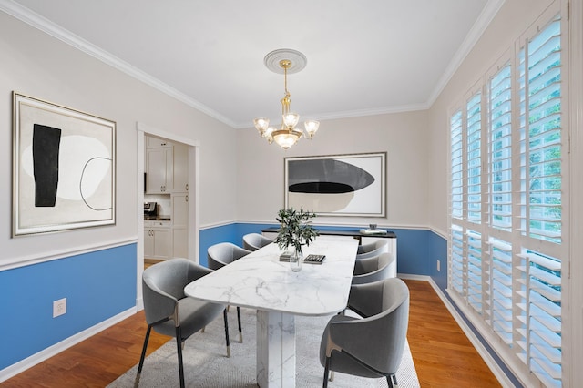 dining space with a chandelier, hardwood / wood-style flooring, and crown molding