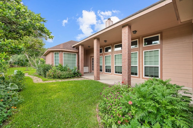 rear view of property featuring a patio and a yard