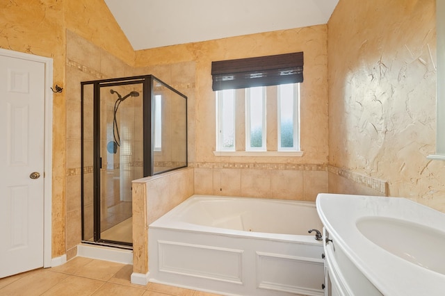 bathroom with tile patterned flooring, shower with separate bathtub, vaulted ceiling, and vanity