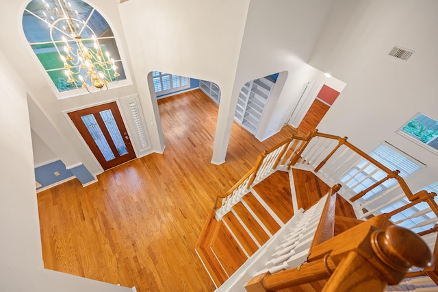 foyer featuring a high ceiling, wood-type flooring, and a chandelier