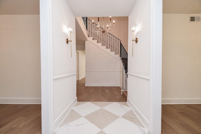 stairway featuring a chandelier and hardwood / wood-style flooring