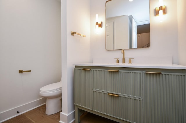 bathroom with toilet, wood-type flooring, and vanity