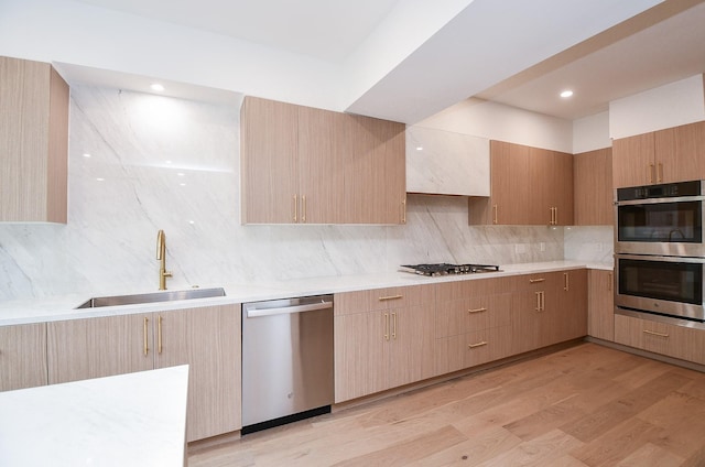 kitchen with light brown cabinetry, appliances with stainless steel finishes, backsplash, and sink