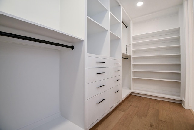 walk in closet with light hardwood / wood-style floors