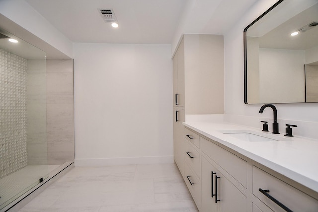 bathroom featuring tiled shower and vanity