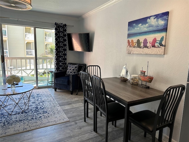 dining space with hardwood / wood-style flooring and ornamental molding