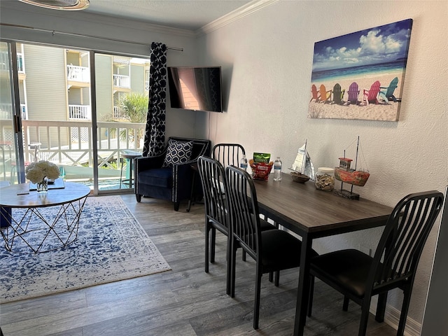 dining space with ornamental molding and hardwood / wood-style flooring