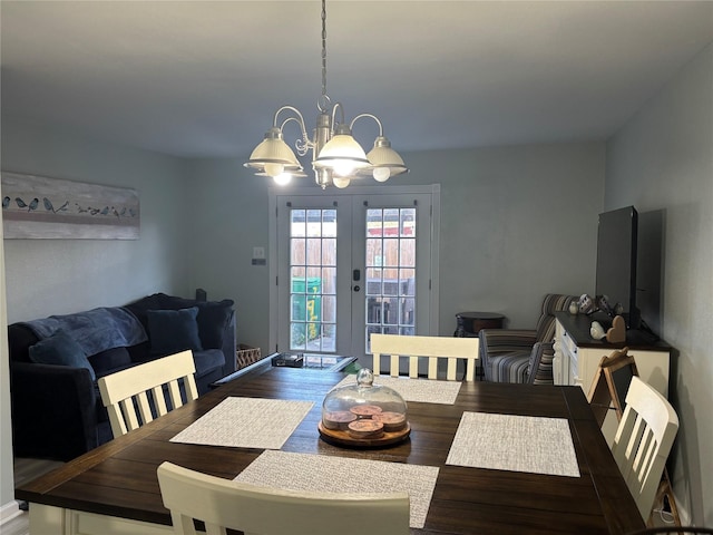 dining room with french doors, a chandelier, and wood-type flooring