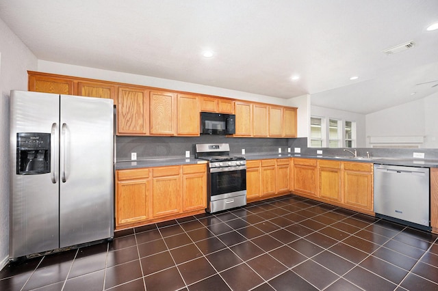 kitchen featuring sink, stainless steel appliances, vaulted ceiling, and tasteful backsplash