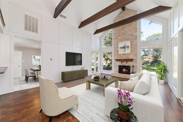 living room with a brick fireplace, high vaulted ceiling, beamed ceiling, and hardwood / wood-style flooring