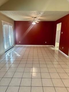 empty room featuring ceiling fan, lofted ceiling, and light tile patterned floors