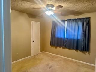 carpeted spare room with a textured ceiling and ceiling fan