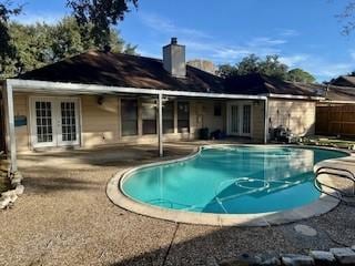 view of swimming pool with a patio and french doors