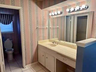 bathroom featuring vanity, tile patterned floors, and toilet