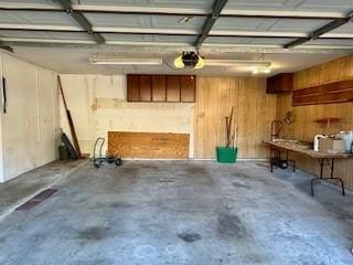 garage with a garage door opener and wood walls