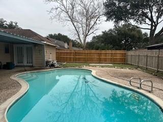 view of swimming pool featuring a patio and french doors