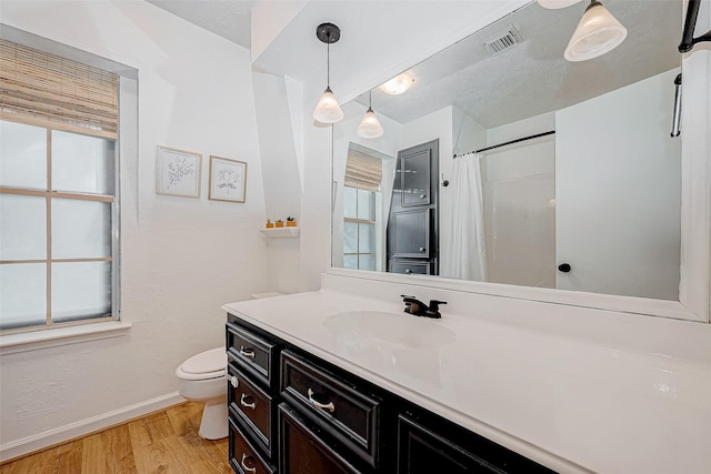 bathroom featuring a shower with shower curtain, toilet, vanity, and wood-type flooring