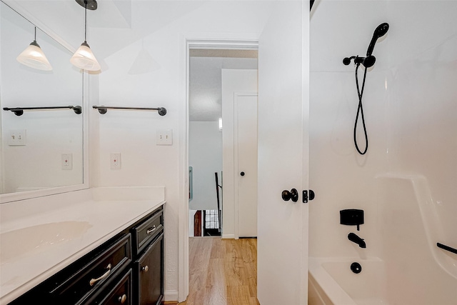 bathroom with shower / tub combination, wood-type flooring, and vanity