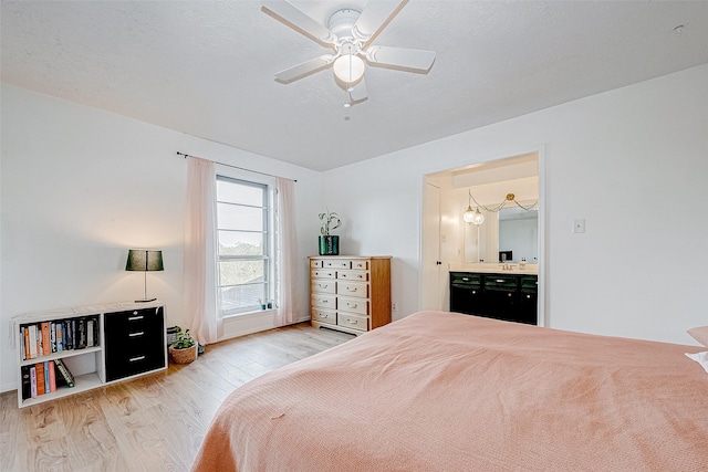 bedroom with ensuite bathroom, a textured ceiling, ceiling fan, and light hardwood / wood-style flooring