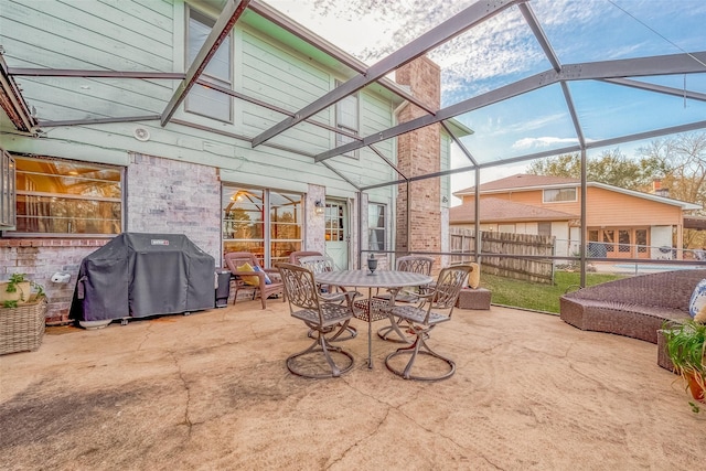 view of patio / terrace with glass enclosure and a grill