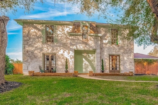 view of front of home with a front yard and french doors