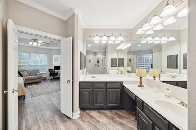 bathroom with hardwood / wood-style flooring, a shower with door, ceiling fan, and vanity